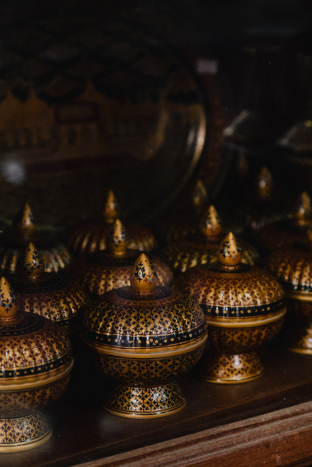 A hand-painted Benjarong porcelain vessel with gold and polychrome floral medallions